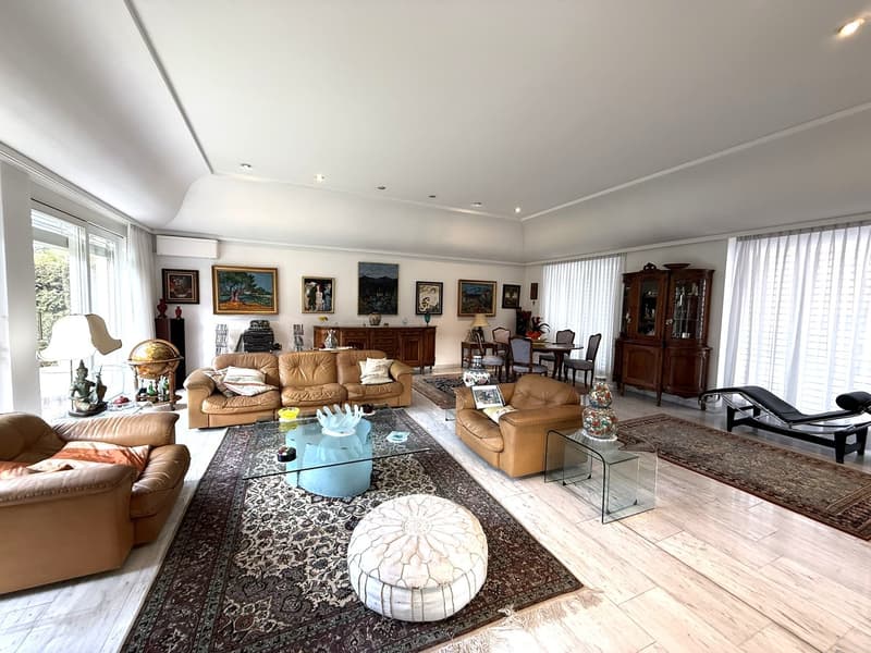 3 couches, glass table, ottoman, oriental rug, wooden floor, dining table, artwork on wall, window with curtains