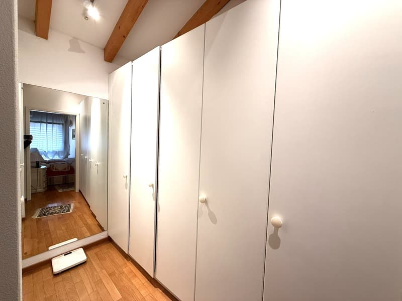 empty room, white wardrobes, mirror, wooden floor, bed in another room