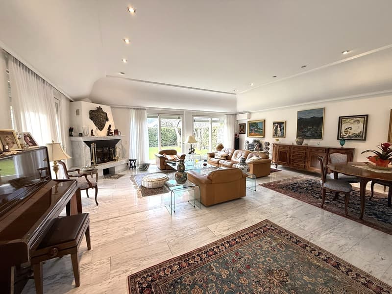 marble flooring, fireplace, glass windows, large sofa, glass coffee table, armchairs, wooden cabinet, painting, dining table and chairs, grand piano