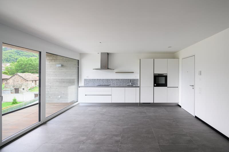 modern kitchen with white cabinets, gray tiled floor, large windows, and a view of the outside