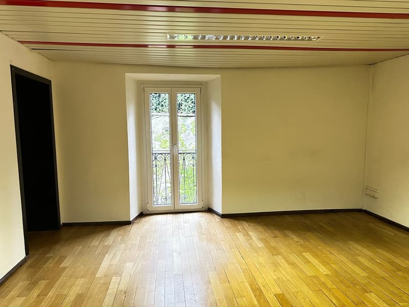 empty room, wooden floor, white walls, glass door with balcony, ceiling with red stripe