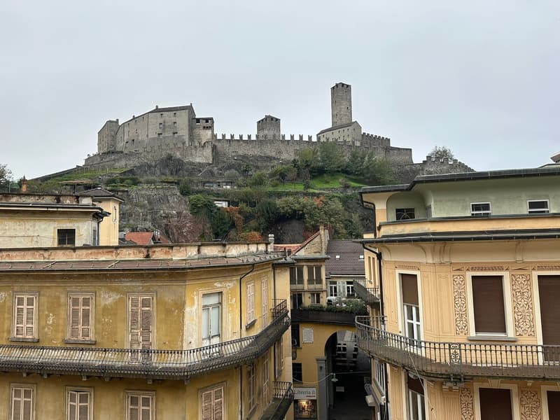 Old buildings with balconies, a castle on a hill, narrow street