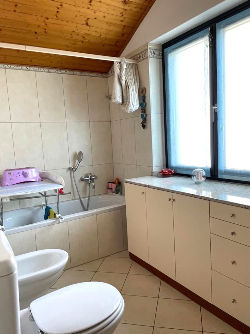 Bathroom with bathtub, toilet, sink, and window