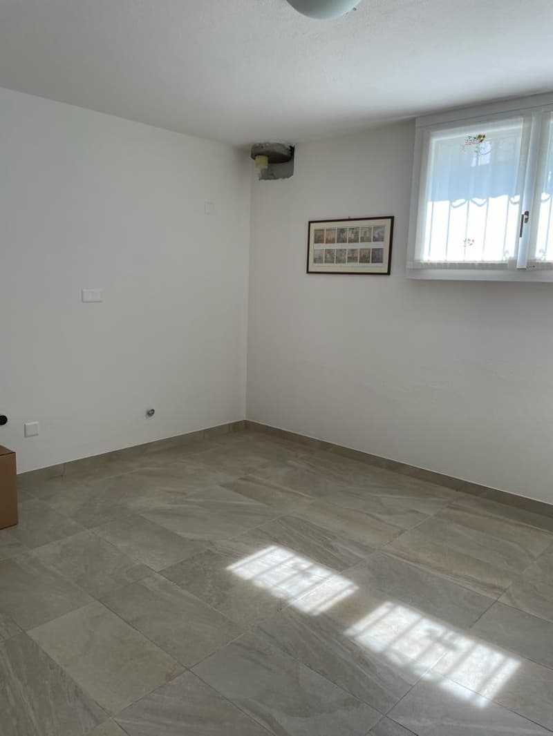 empty room, white walls, tiled floor, window with white curtains, picture frame on wall
