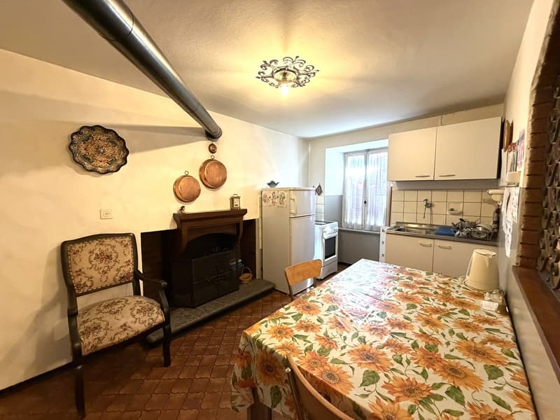 kitchen with dining area, fireplace, white cabinets, white refrigerator, white oven, dining table with floral tablecloth, wooden chair, tiled floor