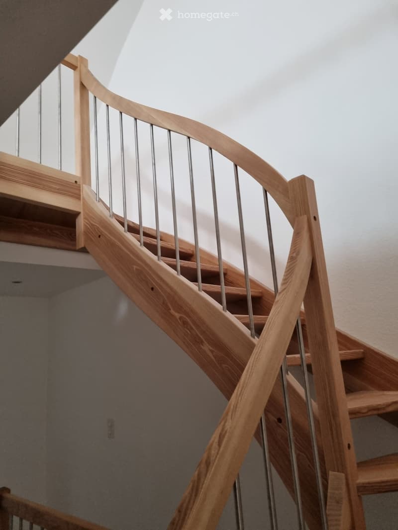 Modern wooden staircase with steel handrail