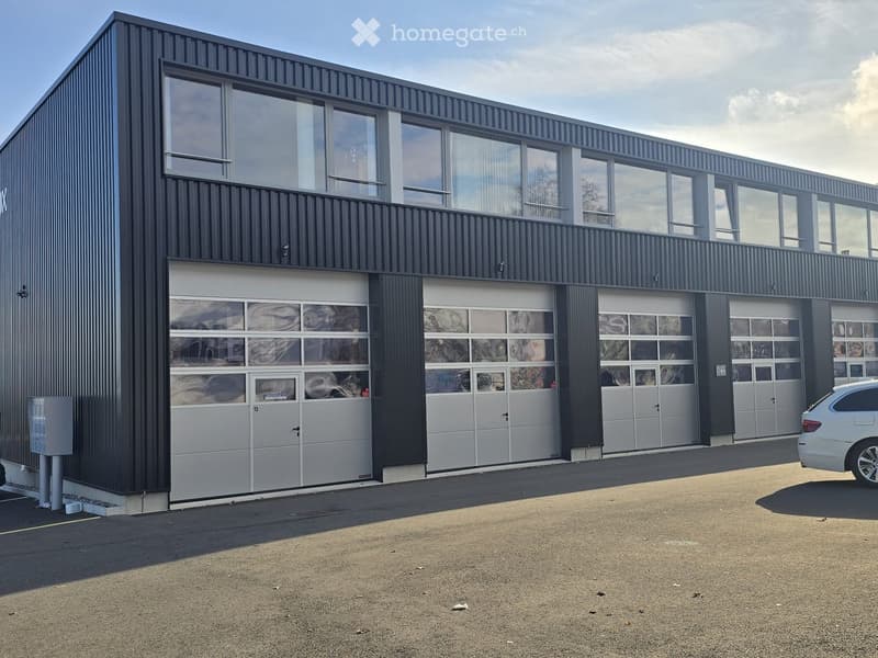 Modern building, large garage doors, large windows, flat roof