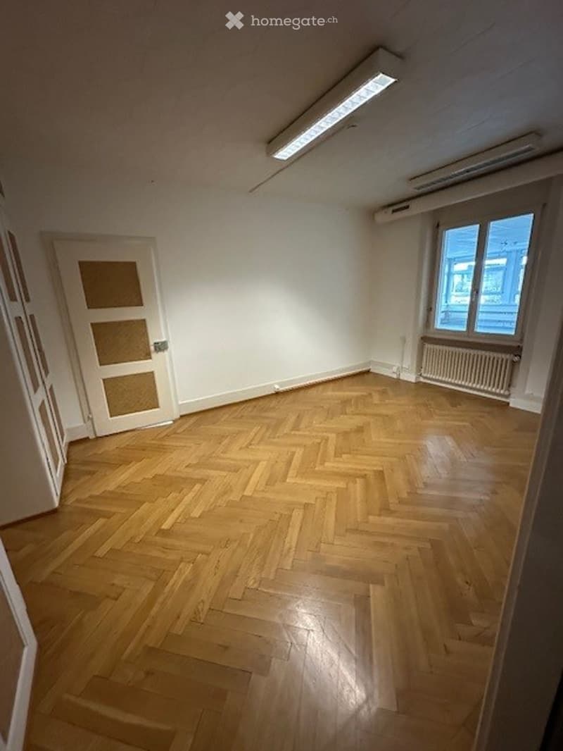 empty room, wooden floor, white walls, door, radiator, window