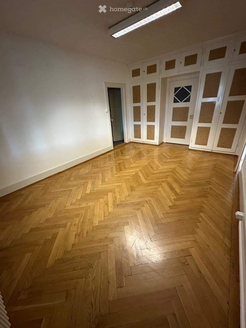 empty room, wooden parquet floor, white walls, ceiling light