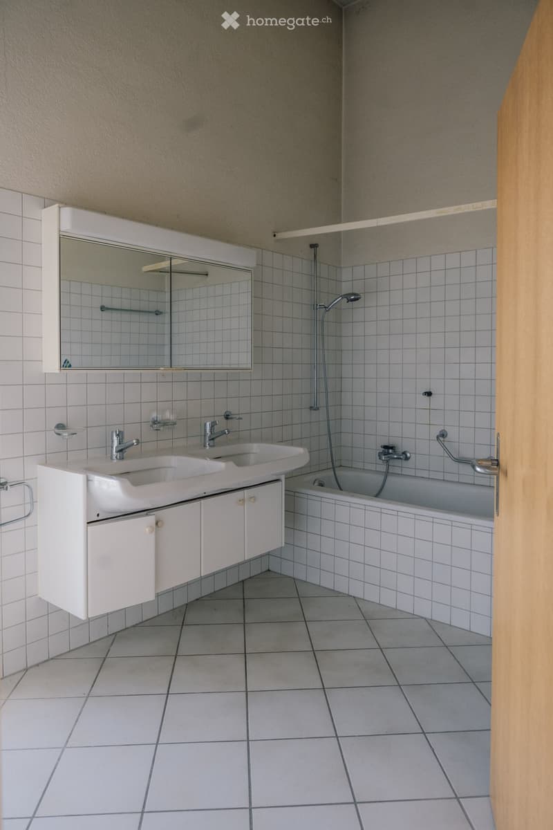 Bathroom with white tiles, double sink, bathtub, mirror, and shower