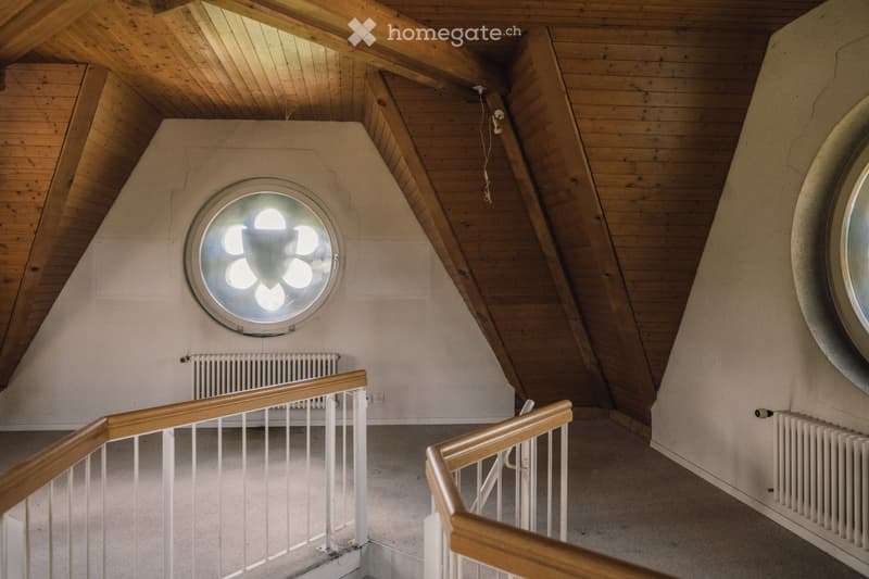 wooden ceiling, white walls, round window, wooden handrails, radiators
