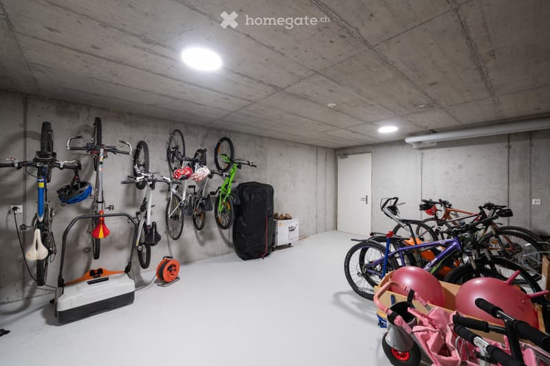 underground parking with bicycles, exercise equipment, and storage boxes