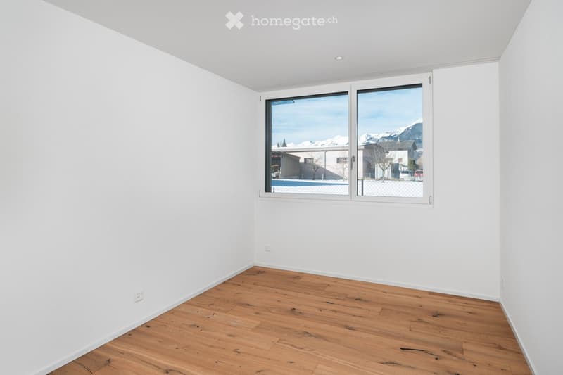 empty room with white walls, wooden floor, large window, mountain view