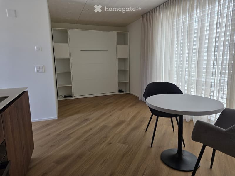 Modern furnished room with a white table, two chairs, a white cupboard, shelves, and power outlets.