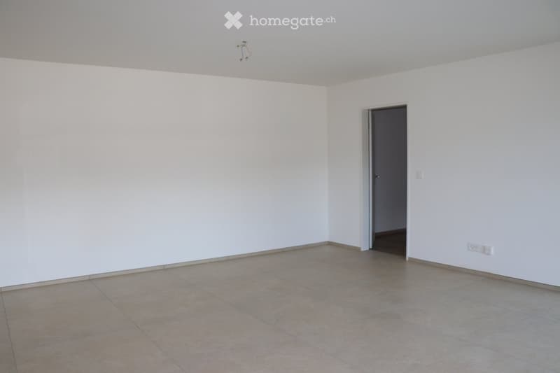 empty room with white walls, tiled floor, power outlets, door