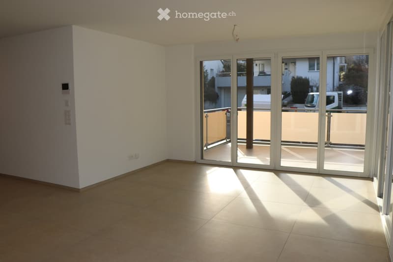 empty room, large glass sliding doors leading to balcony, tile floor, white walls, power outlets
