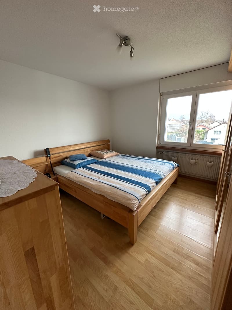bedroom with bed, wooden furniture, large window