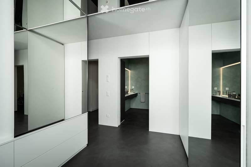 modern bathroom with white walls, black floor, large mirror, sink, towel rack, recessed lighting