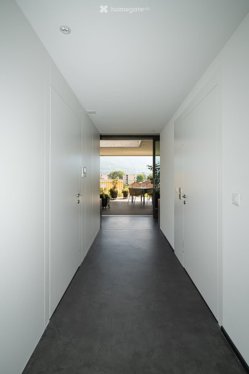 white walls, gray floor, open door to balcony, modern design