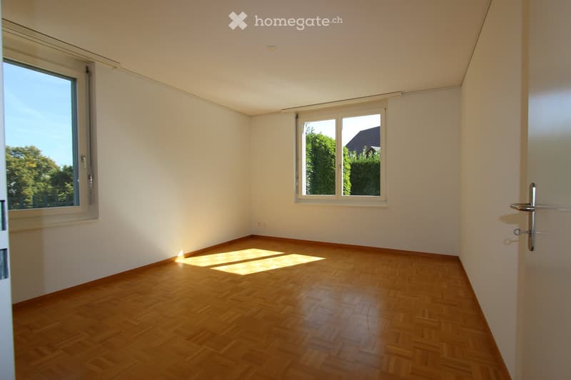 empty room, wooden floor, white walls, two windows, sunlight streaming in