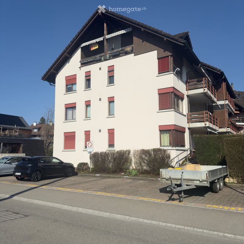 3 story house, white walls, red shutters, brown roof, balcony, cars parked in front