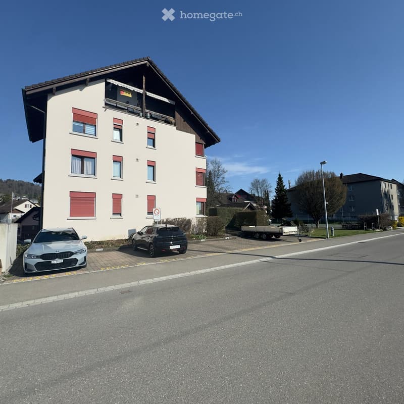 3 story house, white walls, red shutters, 2 cars parked in front