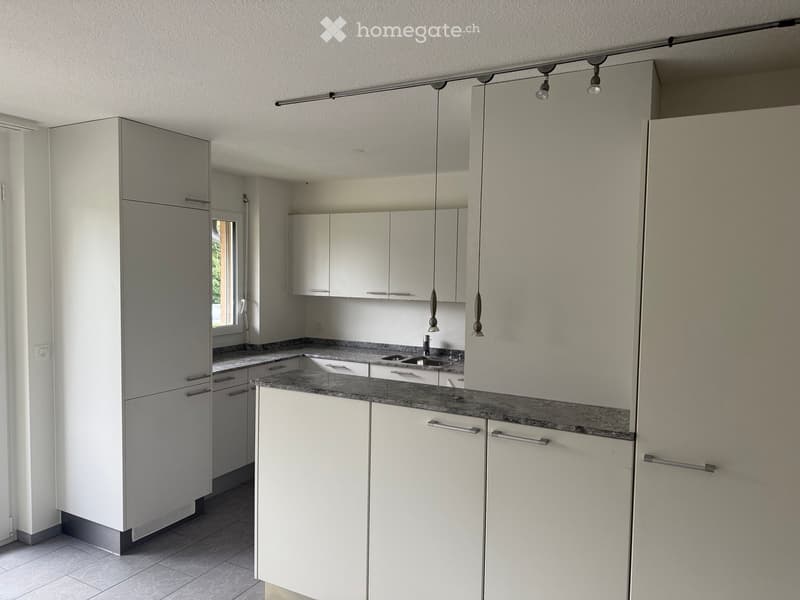 modern kitchen with white cabinets, granite countertops, stainless steel sink, and a window