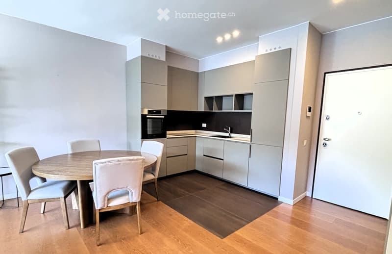 modern kitchen with dining area, wooden floor, white walls, round dining table, 4 chairs, built-in oven, sink, cabinets