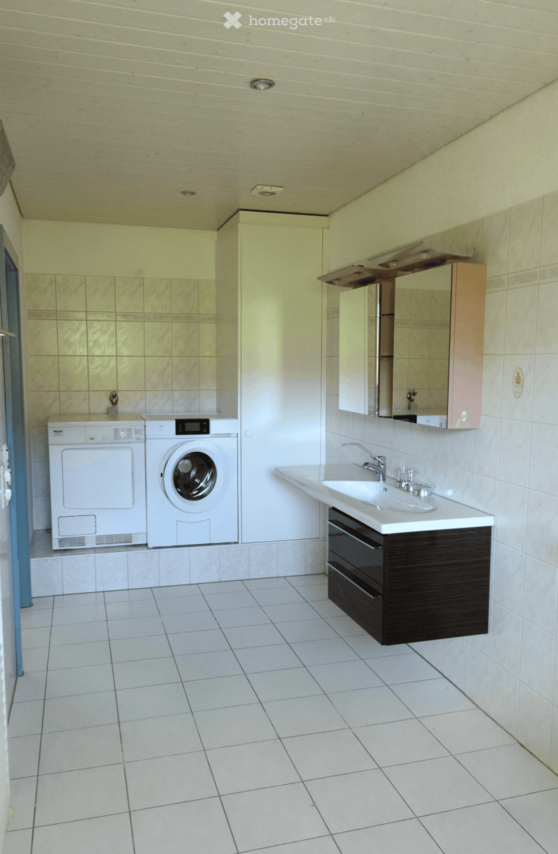 Laundry room with washing machine, dryer, sink, and mirror