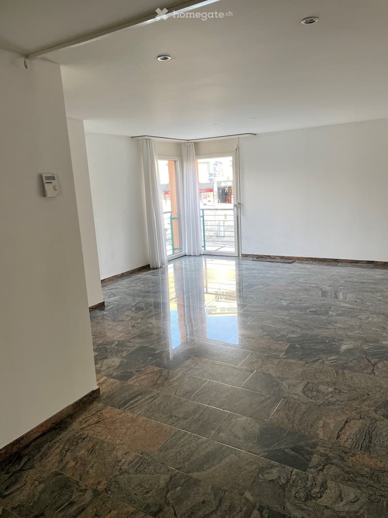 Empty room with marble floor, white walls, sliding glass door, balcony