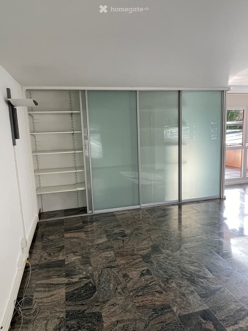 empty room, white walls, marble floor, glass sliding doors, white shelves, power outlet