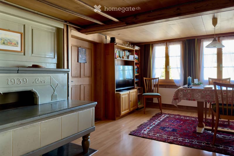 wooden floor, fireplace, dining table, chairs, rug, TV, bookshelf, picture frame, windows