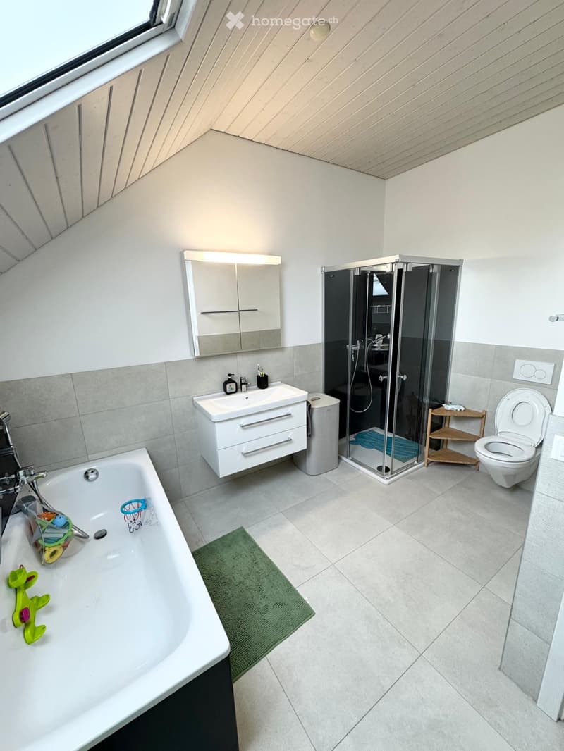 modern bathroom with bathtub, shower, toilet, sink, mirror, and wooden shelf