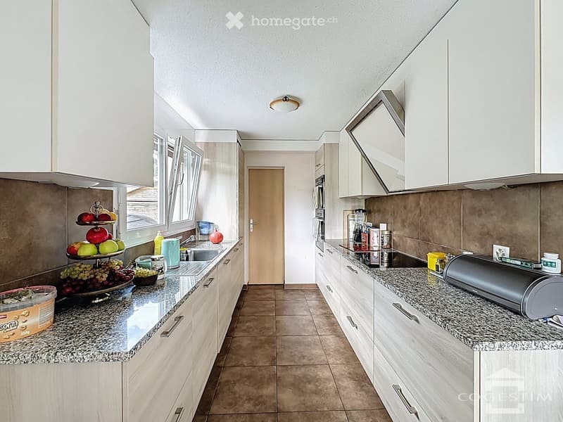 modern kitchen with granite countertops, white cabinets, tiled floor, ceiling lamp, sink, faucet, fruits on countertop, microwave, refrigerator, power outlet, toaster