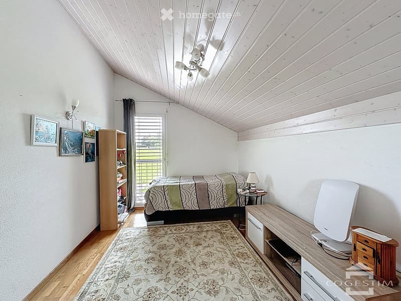 bedroom with bed, rug, wooden cabinet, lamp, shelves, pictures, ceiling fan, wooden floor