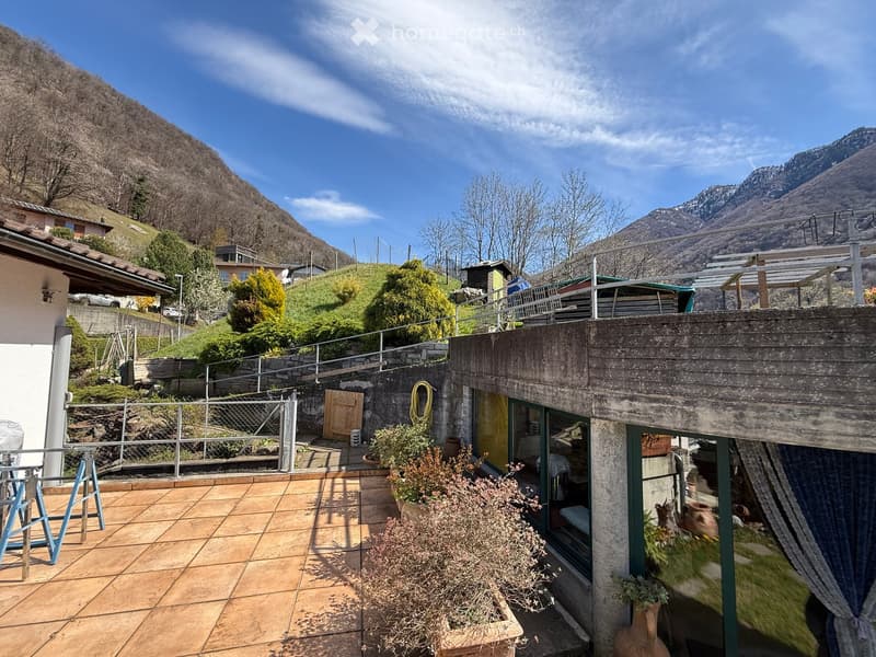 House with a terrace, surrounded by mountains, with a view of the valley