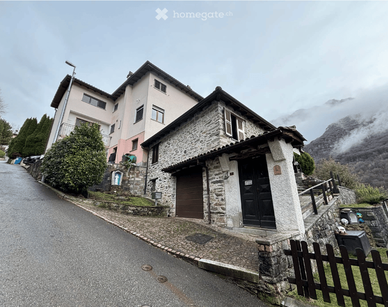 2 story house, stone and brick, brown garage, black door, mountain view