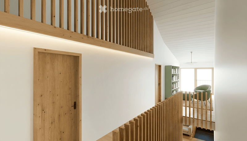wooden door, wooden railing, white walls, wooden ceiling, wooden floor, green bookshelf, white chair, white sofa