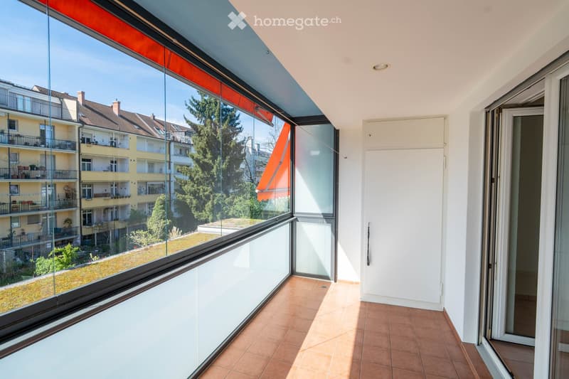 large glass windows, tiled floor, white walls, balcony with retractable awning