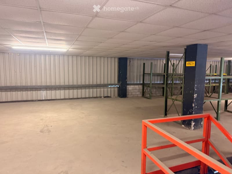 Empty room, metal walls, metal shelves, concrete floor, metal railings, fluorescent ceiling light