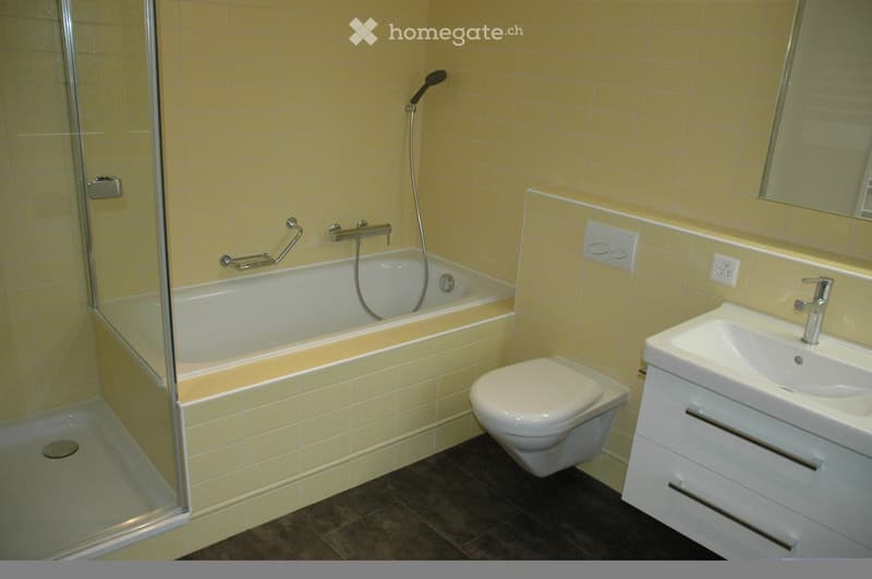 Bathroom with yellow tiles, bathtub, shower, toilet, sink, mirror, and power outlet