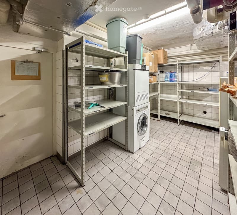 Storage room with shelves, washing machine, buckets, boxes, and a clipboard on the wall