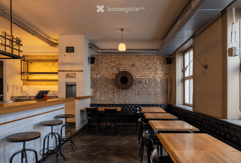 wooden tables, black chairs, black leather bench, brick wall, wooden counter, digital clock, hanging lamps, pendant light