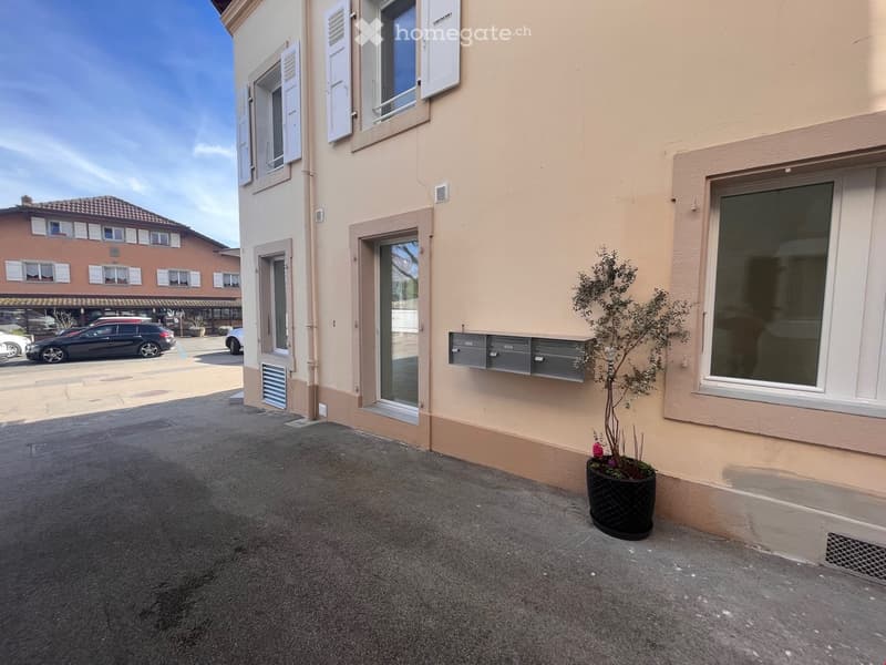 2 story house, beige exterior, white windows, mailboxes, potted plant, parking lot