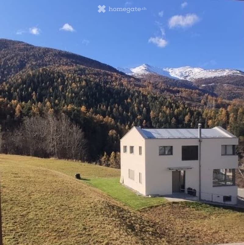 House. Modern white house with a flat roof, set in a mountainous landscape with snow-capped peaks.