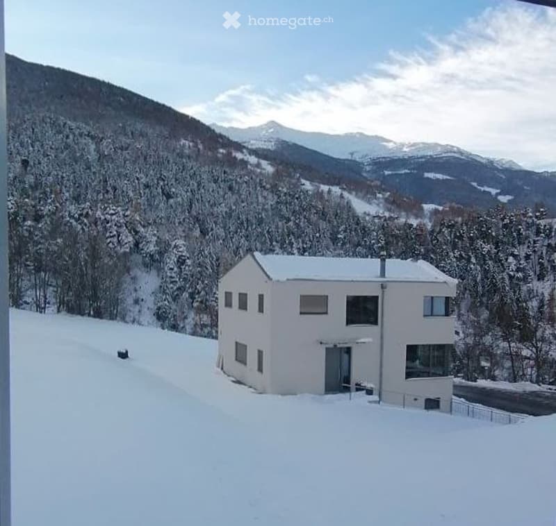 House. Modern white house on a snowy mountain slope with a clear view of the mountains.