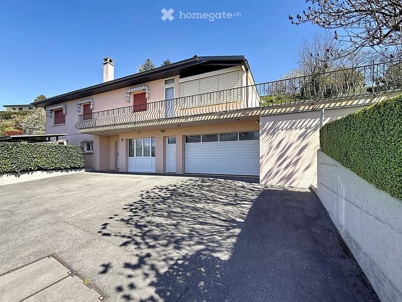 2 story house, pink exterior, balcony, 2 garages, driveway