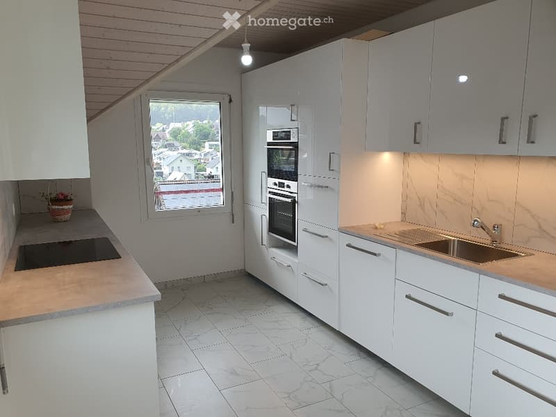 Kitchen. Modern kitchen with white cabinets, marble countertops, induction cooktop, and built-in oven and microwave.