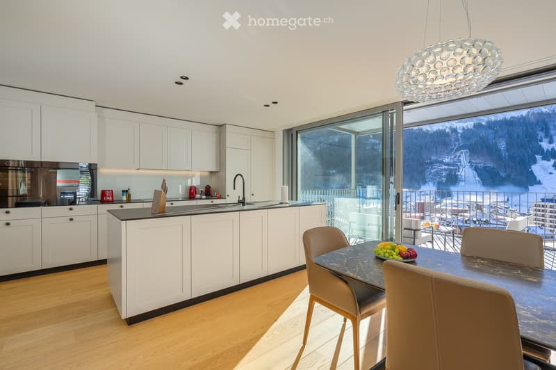 white cabinetry, wooden floors, modern appliances, central island, open balcony, large windows