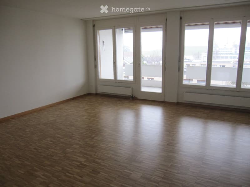 Unfurnished Room. Empty room with wooden flooring, large windows, and radiators along the walls.